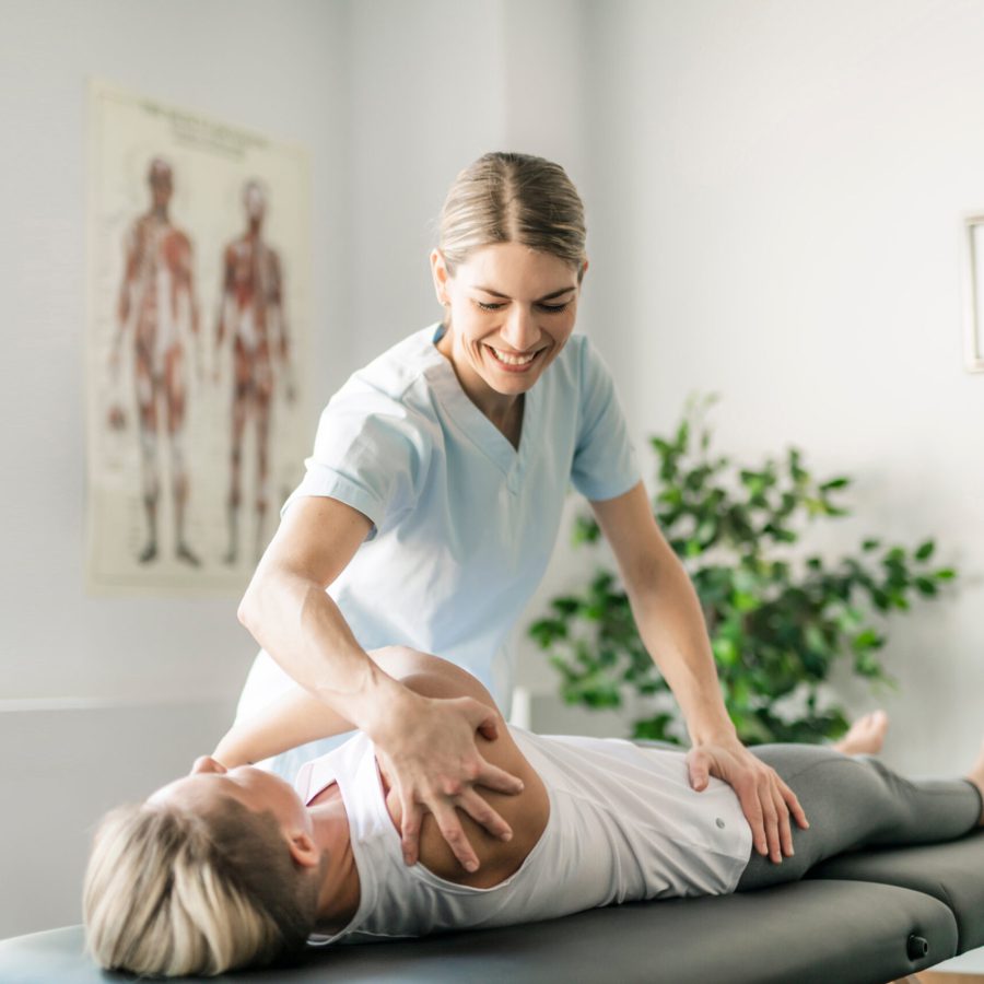 Modern rehabilitation physiotherapy worker with woman client